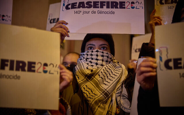 Un manifestant tient une pancarte sur laquelle on peut lire "Cessez-le-feu 2024" près de l'Olympia lors de la 49e édition de la cérémonie des César du cinéma à Paris, le 23 février 2024. (Crédit : Kiran RIDLEY / AFP)