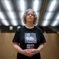 L'ex-otage du Hamas Aviva Siegel pose avec un t-shirt montrant une photo de son mari Keith Siegel lors d'une interview avec l'AFP pendant sa visite à la 55e session du Conseil des droits de l'homme de l'ONU à Genève, le 28 février 2024. (Crédit : Fabrice COFFRINI / AFP)