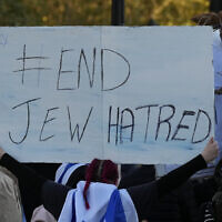 Une israélienne brandit une pancarte disant "Mettez fin à la haine des juifs" à une manifestation où des pancartes portant les visages et les noms de personnes prises en otage et détenues à Gaza ont été brandies lors d'une manifestation à Trafalgar Square, à Londres, le 22 octobre 2023. (Crédit : AP Photo/Frank Augstein)