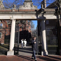 Illustration : Un passant franchit une porte menant au campus de l'Université Harvard à Cambridge, dans le Massachusetts, le 2 janvier 2024. (Crédit : Steven Senne/AP Photo)