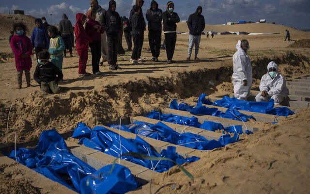 Des Palestiniens enterrant les corps de personnes tuées lors de combats avec Israël et renvoyées à Gaza par l'armée israélienne, lors de funérailles collectives, à Rafah, dans la bande de Gaza, le 30 janvier 2024. (Crédit : Fatima Shbair/AP)