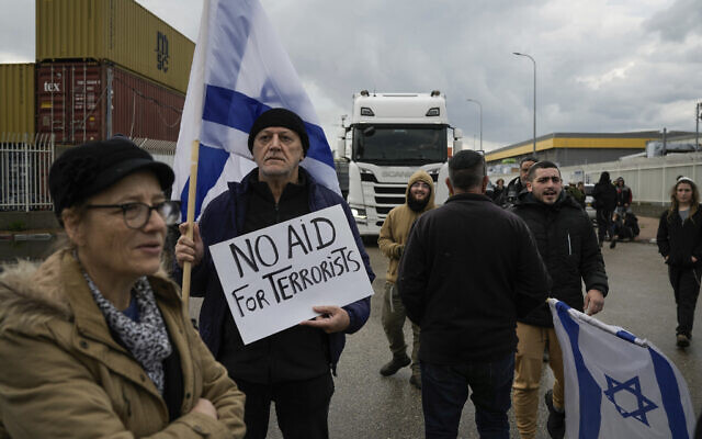 Des manifestants bloquant la sortie du port d'Ashdod pour arrêter des camions qui, selon eux, transportent de l'aide humanitaire destinée à la bande de Gaza, à Ashdod, le 1er février 2024. (Crédit : Leo Correa/AP Photo)