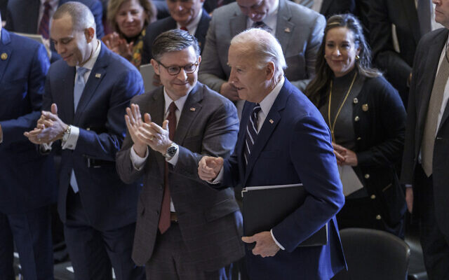 Le président Joe Biden, à droite, et le président de la Chambre Mike Johnson, au centre, pendant le National Prayer Breakfast,  le 1er février 2024. (Crédit : AP/J. Scott Applewhite)