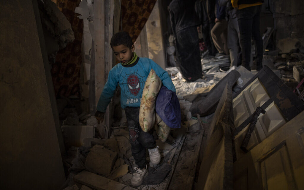 Des Palestiniens ramassant leurs affaires dans leur maison endommagée après une frappe aérienne israélienne à Rafah, dans le sud de la bande de Gaza, le 8 février 2024. (Crédit : Fatima Shbair/AP Photo)