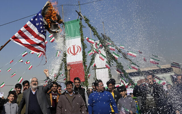 Des manifestants brûlent un drapeau américain pendant un rassemblement annuel commémorant la révolution islamique de 1979 en Iran, à Téhéran, le 11 février 2024. (Crédit : AP Photo/Vahid Salemi)