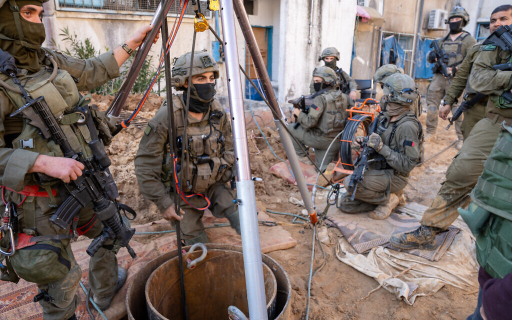 Les troupes de l'unité de génie Yahalom font descendre une caméra dans un puits de tunnel creusé dans la cour du siège de l'UNRWA à Gaza, le 8 février 2024. (Crédit : Emanuel Fabian/Times of Israel)