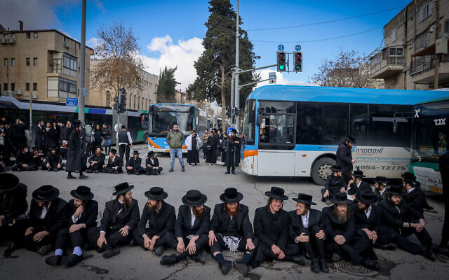 Des haredim bloquant une route de Jérusalem lors d'une manifestation contre l'autopsie d'un jeune garçon décédé la veille, le 6 février 2024. (Crédit : Chaïm Goldberg/Flash90)