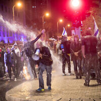 La police utilise un canon à eau pour disperser les manifestants qui s'opposent au gouvernement et au Premier ministre Benjamin Netanyahu à Tel Aviv, le 24 février 2024. (Crédit : Miriam Alster/Flash90)