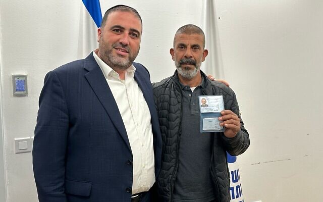 Le ministre de l'Intérieur, Moshe Arbel, aux côtés de Hamid Abu Arar montrant sa nouvelle carte d'identité israélienne, le 21 février 2024. (Crédit : Autorisation)