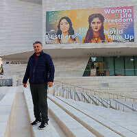 L'artiste irano-américain Hooman Khalili devant une peinture murale qu'il a réalisée sur le mur extérieur du Musée de la Tolérance de Jérusalem représentant la soldate irano-israélienne Shirel Pour Haïm (à gauche), et Mahsa Amini, jeune femme tuée par le régime, déclenchant des manifestations en Iran, à Jérusalem, le 30 janvier 2024. (Crédit : Gianluca Pacchiani/Times of Israel)