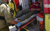 Les forces de sécurité israéliennes évacuent un Thaïlandais blessé par un missile anti-char tiré depuis le Liban, à Kiryat Shoma, le 4 mars 2024. (Crédit : AP Photo/Ariel Schalit)