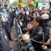 Des agents de la police de New York en tenue anti-émeute montent la garde alors que des manifestants scandent des slogans à l'extérieur du campus de l'université Columbia, le 18 avril 2024, à New York. (Crédit : Mary Altaffer/AP)