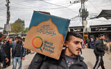 Un homme portant une boîte en carton contenant de l'aide alimentaire fournie par World Central Kitchen, à Rafah, dans le sud de la bande de Gaza, le 17 mars 2024. (Crédit : Mohammed Abed/AFP)