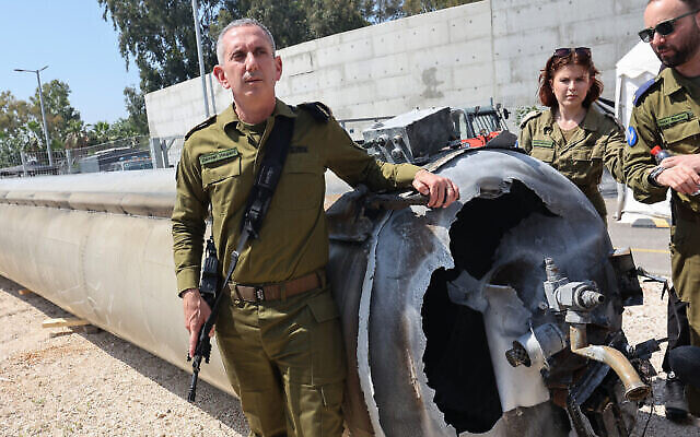Le porte-parole de l’armée israélienne, le contre-amiral Daniel Hagari, à côté d'un missile balistique iranien tombé en Israël lors d'une visite des médias, à la base militaire de Julis, à proximité de Kiryat Malachi, le 16 avril 2024. (Crédit : Gil Cohen-Magen/AFP)