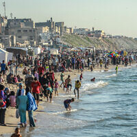Des Palestiniens profitant de la plage à Deir el-Balah, dans le centre de la bande de Gaza, le 17 avril 2024. (Crédit : AFP)