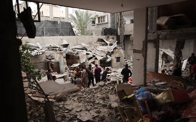 Des badauds inspectant les dégâts survenus dans une maison détruite pendant la nuit, à Rafah, dans le sud de Gaza, le 27 avril 2024. (Crédit : AFP)
