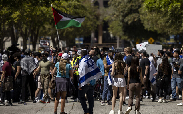 Des manifestants pro-Israël regardant des manifestants anti-Israël et pro-palestiniens sur le campus de l'Université de Californie (UCLA), à Los Angeles, le 28 avril 2024. (Crédit : Etienne Laurent/AFP)