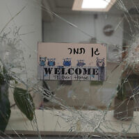 La fenêtre de l'entrée d'un jardin d'enfants brisée par les balles, au kibboutz Beeri, le 11 octobre 2023. (Crédit : Baz Ratner/AP)
