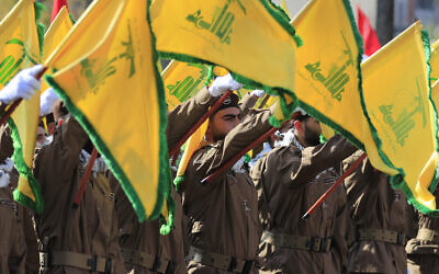 Illustration : Des membres du Hezbollah brandissant des drapeaux du groupe terroriste chiite libanais lors des funérailles d'un commandant et d'un autre terroriste qui ont été tués par une frappe de drone israélienne, dans le village de Chehabiyeh, au sud-Liban, le 17 avril 2024. ( Crédit : Mohammed Zaatari/AP)