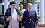 Sur cette photo publiée par le Département de l'information de la presse, le président iranien Ebrahim Raïssi, à gauche, marche avec le Premier ministre pakistanais Shehbaz Sharif à Islamabad, au Pakistan, le 22 avril 2024. (Département de l'information de la presse via AP)