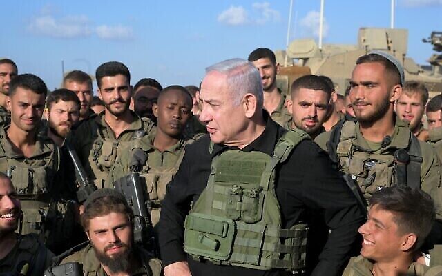 Le Premier ministre Benjamin Netanyahu avec des soldats de la brigade Golani près de la frontière avec Gaza, le 19 octobre 2023. (Crédit : Avi Ohayon/GPO)