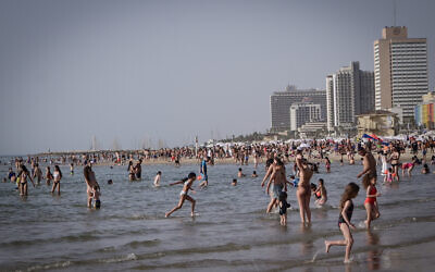 Des gens profitant de la plage lors d'une vague de chaleur, à Tel Aviv, le 24 avril 2024. (Crédit : Avshalom Sassoni/Flash90)