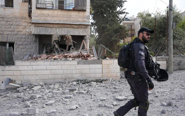 Un officier de police devant la maison démolie d'un terroriste palestinien, dans le quartier de Beit Hanina, à Jérusalem-Est, le 16 avril 2024. (Crédit : Police israélienne)