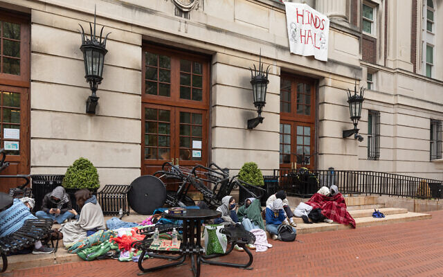 Des manifestants étudiants anti-Israël sont assis devant le Hamilton Hall occupé de l'université Columbia à New York, le 30 avril 2024. (Crédit : Emily Byrski/AFP)