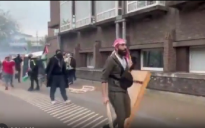 Des militants anti-Israël utilisant des planches de bois pour frapper des étudiants à l'université d'Amsterdam, aux Pays-Bas, le 6 mai 2024. (Crédit : Times of Israel)