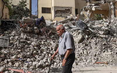 Un Palestinien âgé passe devant des débris au lendemain d'un raid des forces israéliennes à Jénine en Cisjordanie, le 23 mai 2024. (Crédit : Zain JAAFAR / AFP)