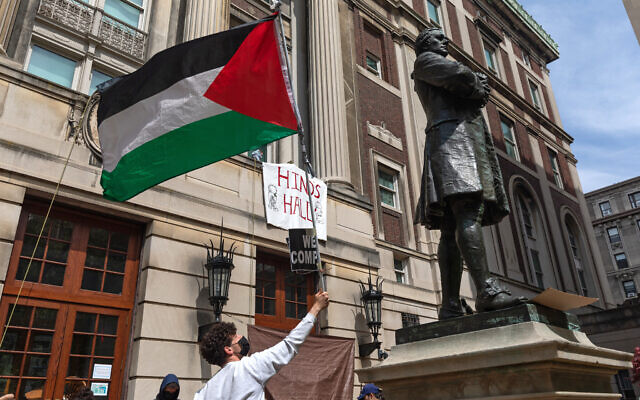 Des étudiants anti-israéliens brandissent un drapeau palestinien alors qu’ils se rassemblent sur les marches du Hamilton Hall de l’Université Columbia à New York, le 30 avril 2024 (Emily Byrski / AFP)