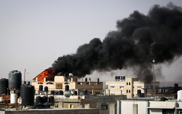 Une épaisse fumée noire s’élevant de l'incendie d'un bâtiment causé par un bombardement israélien, à Rafah, dans le sud de la bande de Gaza, le 10 mai 2024. (Crédit : AFP)