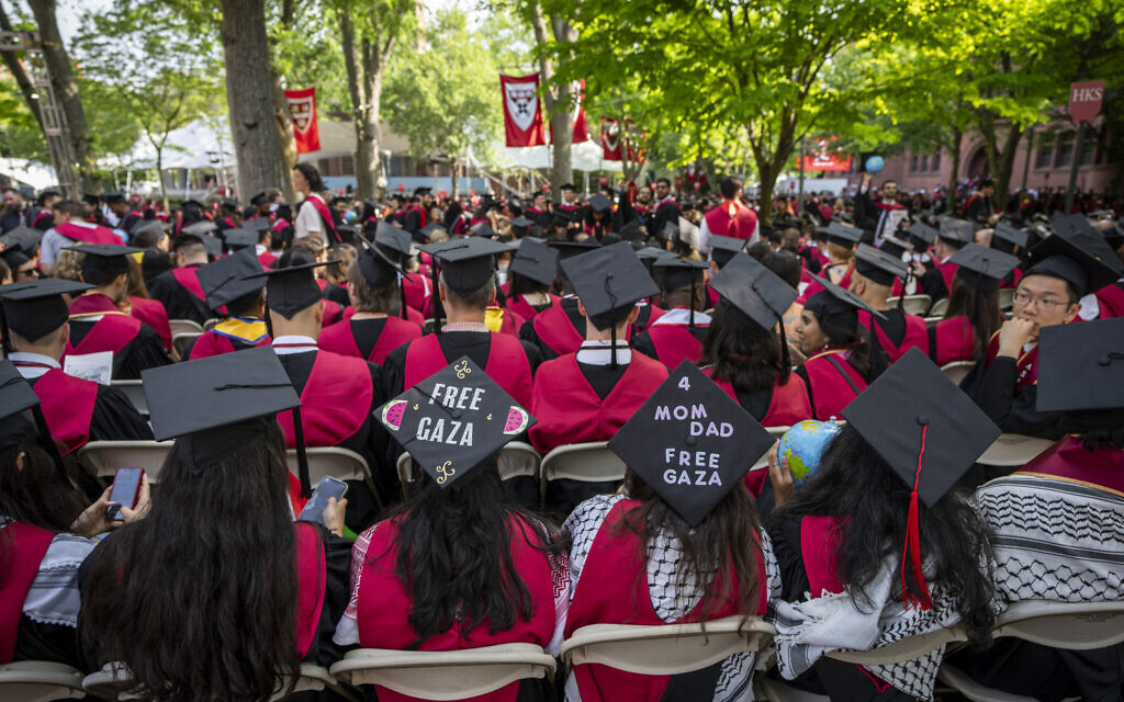 Des étudiants portent des pancartes de soutien à Gaza sur leurs mortiers lors de la cérémonie de remise des diplômes à Harvard Yard, à l'université de Harvard, à Cambridge, Massachusetts, le 23 mai 2024. (Crédit : AP Photo/Ben Curtis)