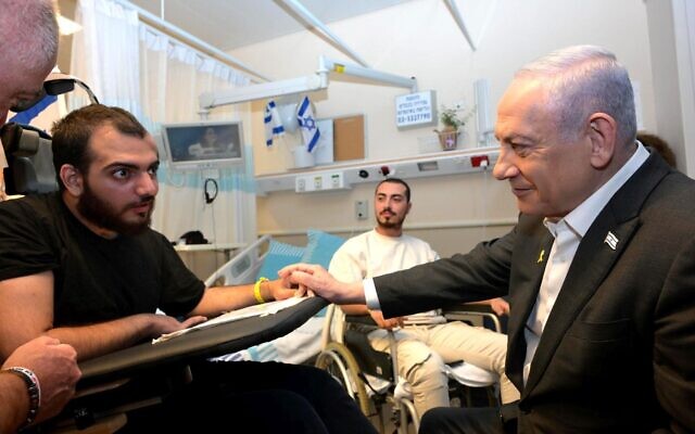 Le Premier ministre Benjamin Netanyahu (à droite) en visite auprès de soldats blessés à l'hôpital Sheba de Ramat Gan, le 14 mai 2024. (Crédit : Amos Ben Gershom/GPO)