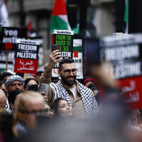 Le photo-journaliste Motaz Azaiza, au centre, rejoint des manifestants anti-israéliens se préparant à défiler dans le centre de Londres, le 18 mai 2024. (Crédit : BENJAMIN CREMEL / AFP)