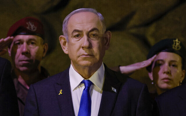 Le Premier ministre Benjamin Netanyahu, au premier plan, assistant à une cérémonie de dépôt de gerbes à l'occasion de la Journée de commémoration de la Shoah dans la salle du souvenir de Yad Vashem, le Centre mondial de commémoration de la Shoah, à Jérusalem, en Israël, le 6 mai 2024. (Crédit : Amir Cohen/AP)