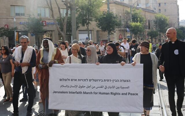 Les leaders religieux à la tête d'une marche interconfessionnelle en soutien à la paix et aux droits de l'Homme dans la rue Jaffa, à Jérusalem, le 3 juin 2024. (Crédit : Jacob Lazarus/Rabbis for Human Rights)