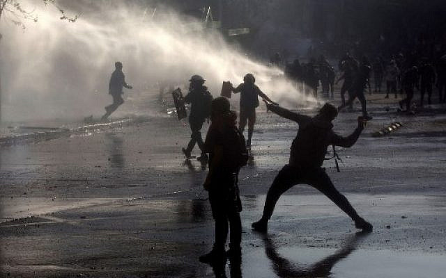 Manifestants affrontant la police anti-émeute lors d'une manifestation contre le gouvernement de Sebastian Pinera à Santiago, Chili, le 22 novembre 2019. Crédit : CLAUDIO REYES / AFP