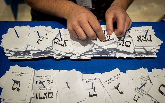 Les travailleurs de la Commission électorale centrale comptent les bulletins de vote restants au parlement israélien à Jérusalem, après les élections générales, le 25 mars 2020. Photo de Yonatan Sindel / Flash90