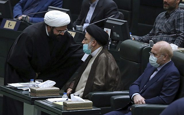 Le président iranien Ebrahim Raisi, au centre, est assis à côté du président du Parlement Mohammad Bagher Qalibaf alors qu'il s'entretient avec un législateur lors d'une session conjointe des législateurs et des membres du cabinet, au parlement, à Téhéran, Iran, le mercredi 1er décembre 2021. Ils se sont rencontrés mercredi pour discuter du budget de l'année prochaine. L'économie iranienne souffre d'une inflation et d'un chômage élevés ainsi que d'un important déficit budgétaire intensifié par les sanctions américaines. (Photo AP/Vahid Salemi)