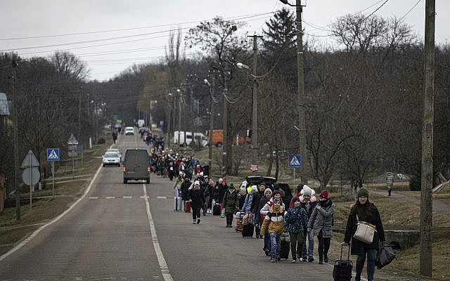 Des réfugiés ukrainiens marchant le long de la route entre Lviv et Shehyni, à Volytsya, en Ukraine, le samedi 5 mars 2022. (AP Photo/Marc Sanye)