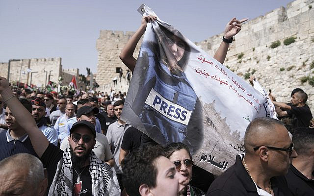 Bannière représentant Shireen Abu Akleh, journaliste d'Al Jazeera, dans la vieille ville de Jérusalem à son lieu de sépulture, le vendredi 13 mai 2022. (AP Photo/Ariel Schalit)