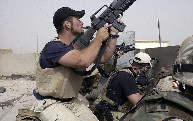 DOSSIER - Dans cette photo d'archive du 4 avril 2004, des sous-traitants en civil travaillant pour Blackwater USA participent à un échange de tirs alors que des manifestants irakiens fidèles à Muqtada al-Sadr tentent d'avancer sur une installation défendue par des soldats américains et espagnols dans la ville irakienne de Nadjaf. Irak. (AP Photo/Gervasio Sanchez, Dossier)