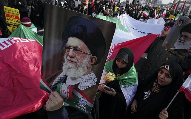 Des manifestants portent un immense drapeau iranien et des affiches du guide suprême, l'ayatollah Ali Khamenei, lors du rassemblement annuel commémorant la révolution islamique iranienne de 1979, à Téhéran, en Iran, le samedi 11 février 2023. L'Iran a célébré samedi le 44e anniversaire de la révolution islamique de 1979, au milieu de manifestations anti-gouvernementales à l'échelle nationale et de tensions accrues avec l'Occident. (AP Photo/Vahid Salemi)