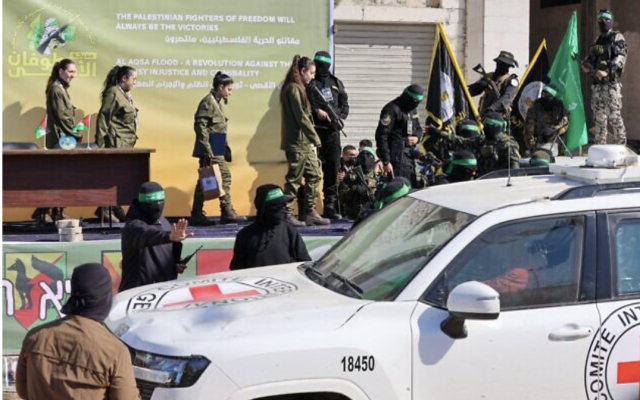 Des terroristes du Hamas escortant quatre otages israéliennes sur une scène avant de les remettre à une équipe de la Croix-Rouge, dans la ville de Gaza, le 25 janvier 2025. (Crédit : Omar al-Qattaa/AFP)