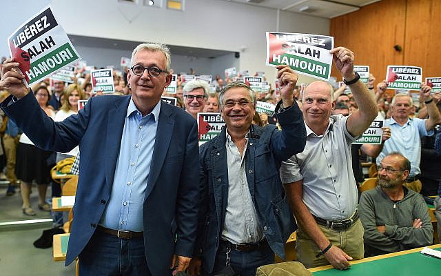 Le secrétaire national du Parti communiste français (PCF), Pierre Laurent (à gauche), et des sympathisants du PCF brandissent des pancartes sur lesquelles on peut lire « Libérez Salah Hamouri », un Franco-Palestinien qui était alors détenu en Israël pour ses liens présumés avec le Front populaire de libération de la Palestine (FPLP), lors de l'université d'été du parti, le 25 août 2018 à Angers, dans l'ouest de la France. (Crédit : JEAN-FRANCOIS MONIER / AFP)