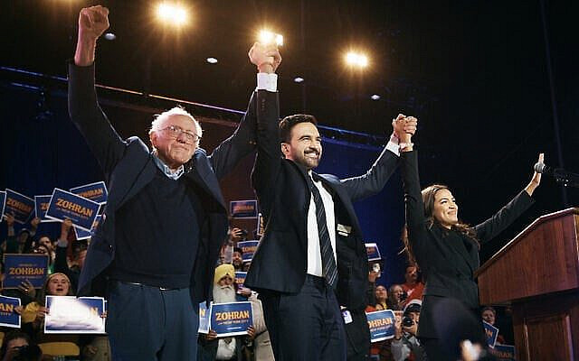 Le candidat à la mairie de New York, Zohran Mamdani, au centre, avec le sénateur américain Bernie Sanders, à gauche, et la représentante américaine Alexandria Ocasio-Cortez, à droite, lors d'un rassemblement électoral le 26 octobre 2025 au Forest Hills Stadium, dans le quartier du Queens, à New York. (Crédit : Andres Kudacki/Getty Images/AFP)