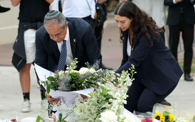 L'ambassadeur d'Israël en Australie, Amir Maïmon (à gauche), déposant des fleurs en hommage aux victimes de l'attentat terroriste meurtrier de Bondi Beach lors d'un événement organisé à l'occasion de Hanoukka, au mémorial du Bondi Pavilion, à Sydney, le 16 décembre 2025. (Crédit : David Gray/AFP)
