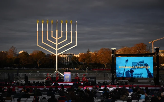 Des personnes assistant à la cérémonie annuelle d'allumage de la menorah nationale, à l'Ellipse de la Maison Blanche à Washington, le 7 décembre 2023. (Crédit : Brendan Smialowski/AFP)