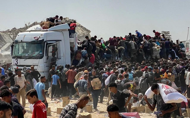 Des Gazaouis déplacés transportant des colis alimentaires après avoir pillé des camions transportant de l’aide humanitaire, à Khan Younès, dans le sud de la bande de Gaza, le 9 août 2025. (Crédit : AFP)